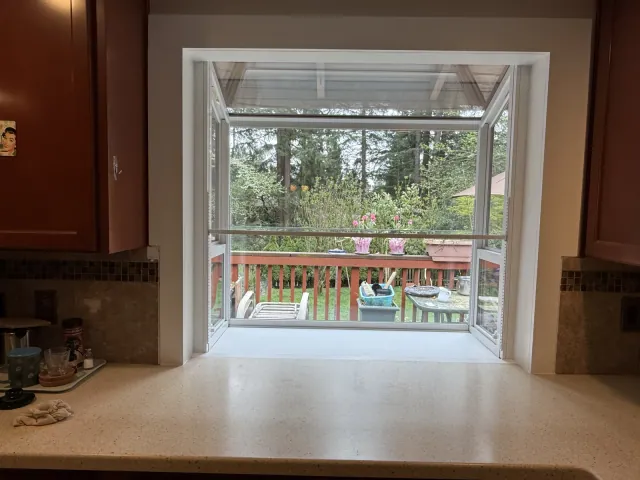 Installed kitchen window with finished white interior trim